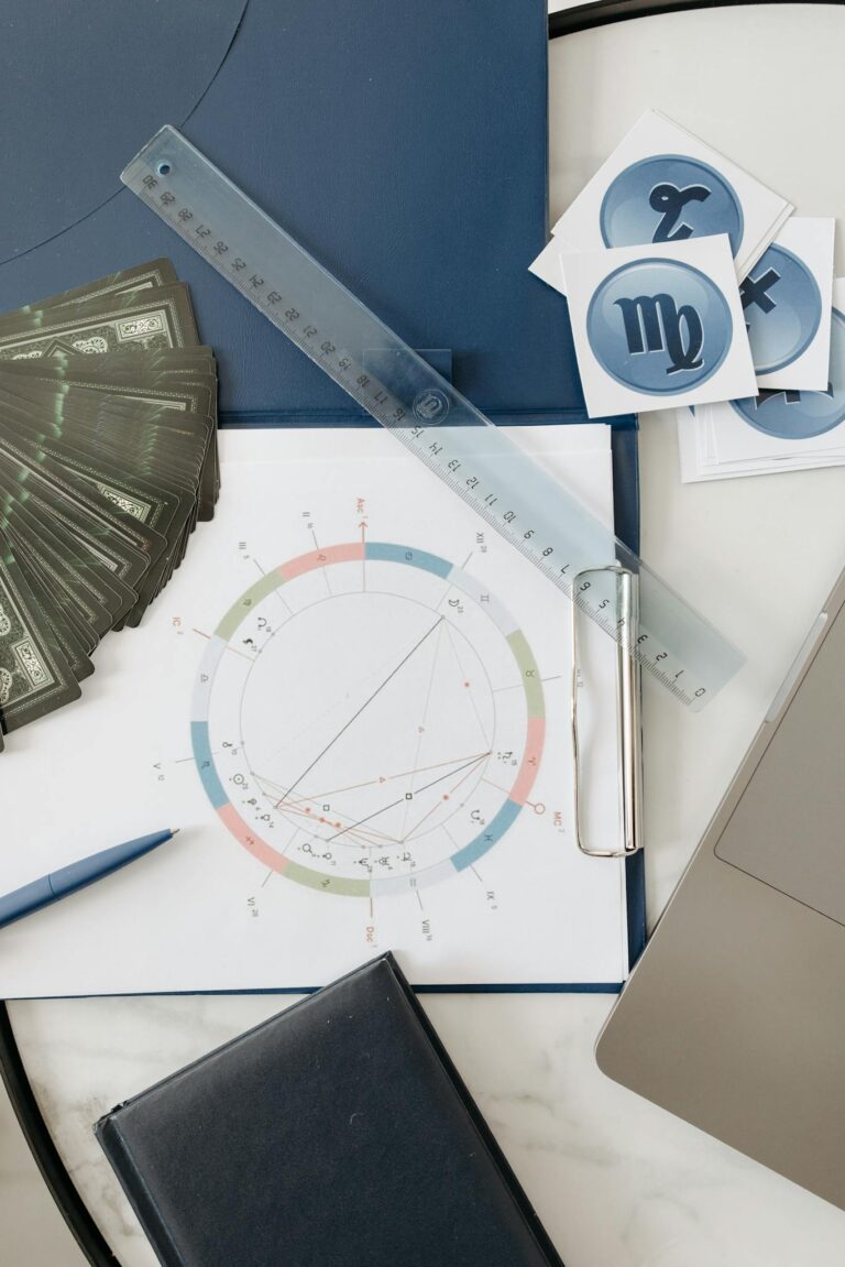 Astrology chart setup with cards, ruler, and symbols on a table.